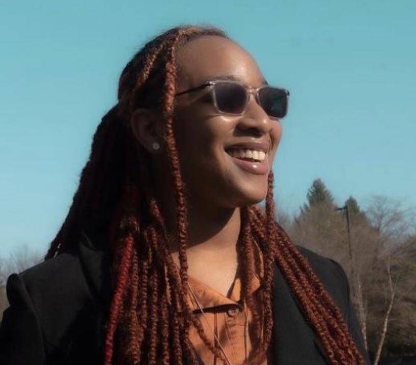 Woman smiling with sunglasses, looking into the distance